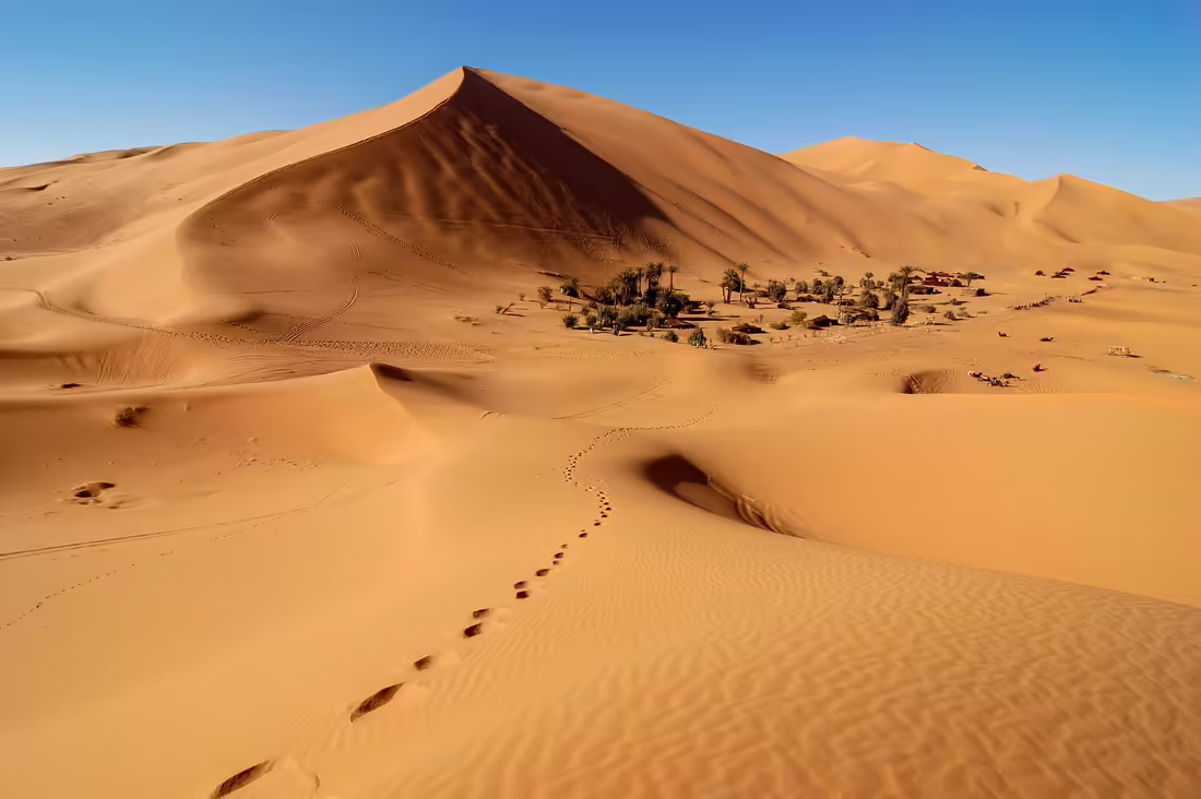 Oáza, budovy a turistické trasy pod vysokou dunou Erg Chebbi