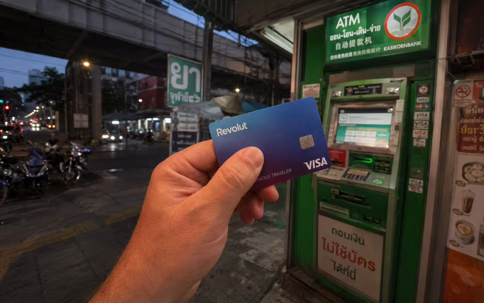 Karta Revolut pred bankomatom Kasikornbank v Thajsku