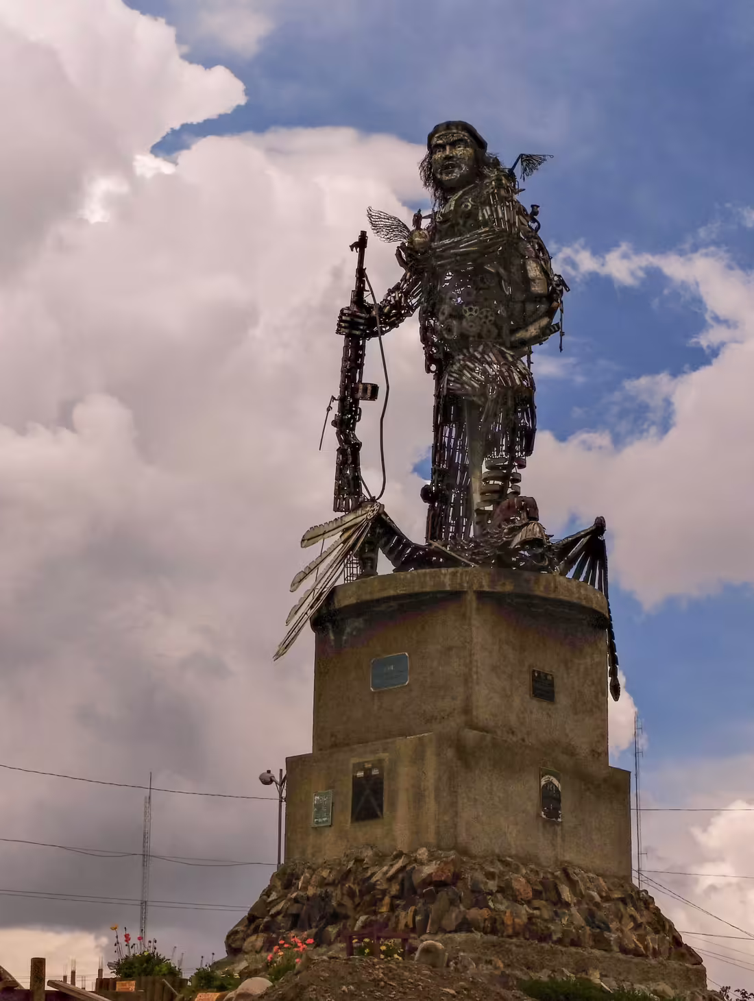 Socha Che Guevaru zo šrotu na vysokom podstavci v El Alte, fotografovaná proti oblohe.