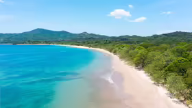 Tyrkysové more a svetlá pláž Playa Conchal na tichomorskom pobreží Kostariky