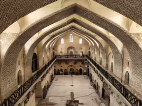 Centrálna hala karavanseraja Khan Murjan v Bagdade s vysokými tehlovými oblúkmi a galériami