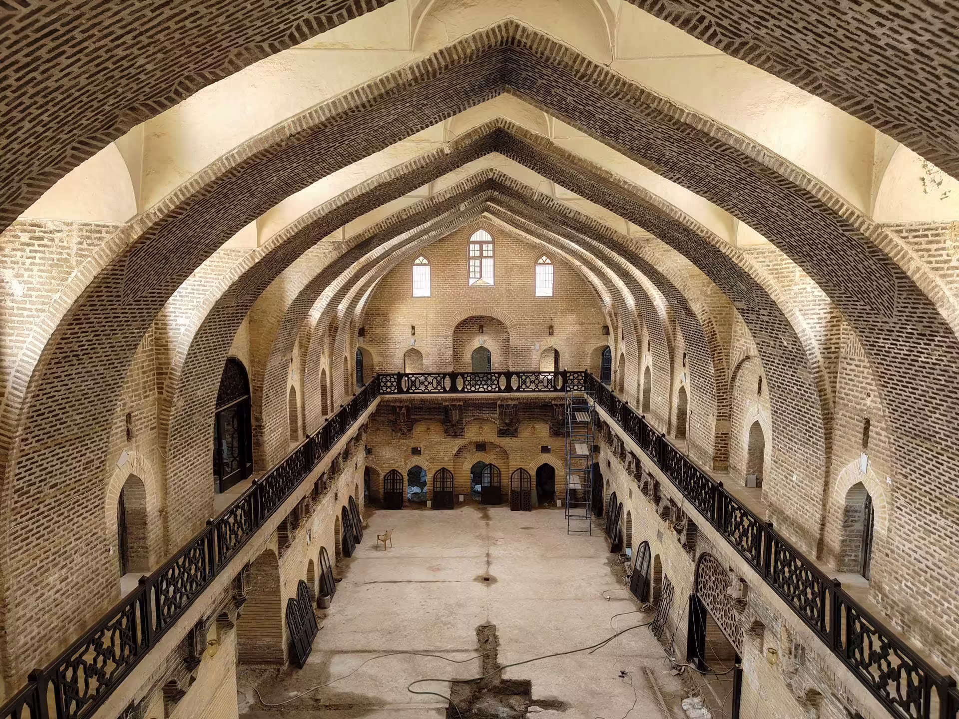 Centrálna hala karavanseraja Khan Murjan v Bagdade s vysokými tehlovými oblúkmi a galériami