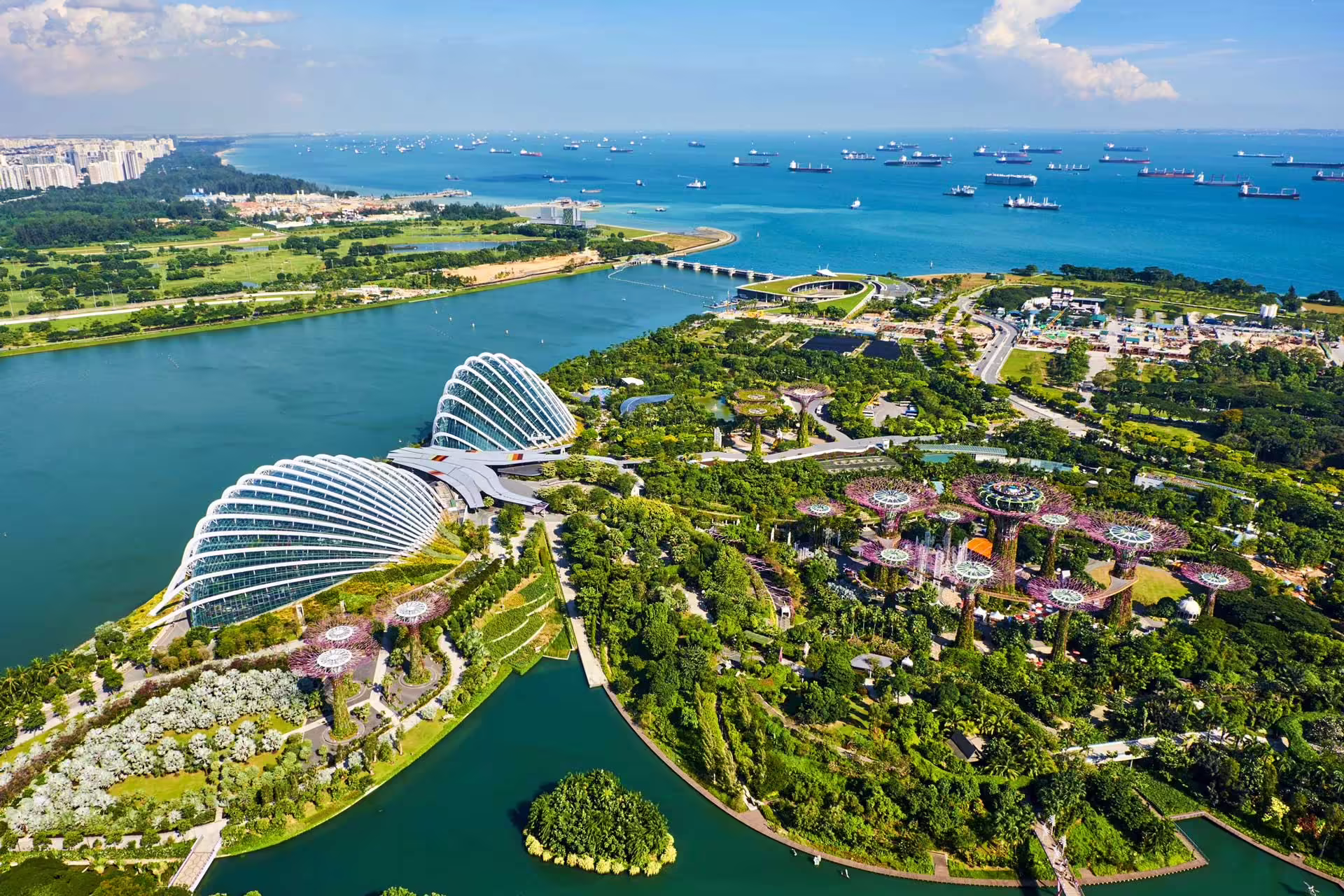 Letecký pohľad na Gardens by the Bay, skleníky Flower Dome a Cloud Forest a pobrežie Singapuru