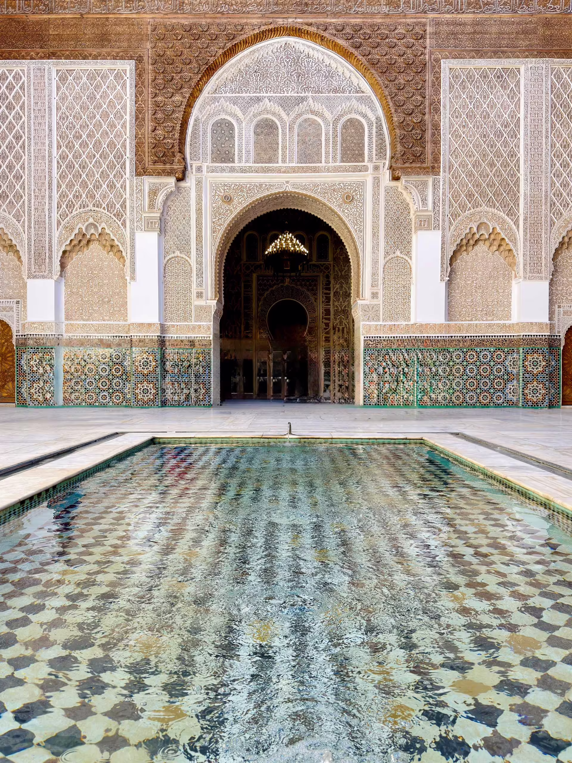 Medresa Ben Youssef – vodná nádrž na nádvorí Vodná nádrž na nádvorí medresy Ben Youssef s mozaikovou dlažbou, zellige obkladmi a štukovou výzdobou
