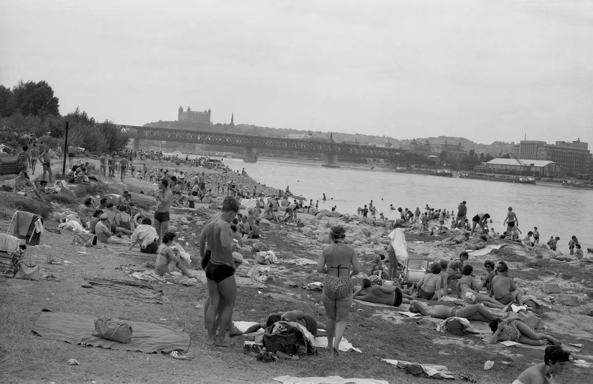 Preplnená dunajská pláž pri Lide so Starým mostom v roku 1962