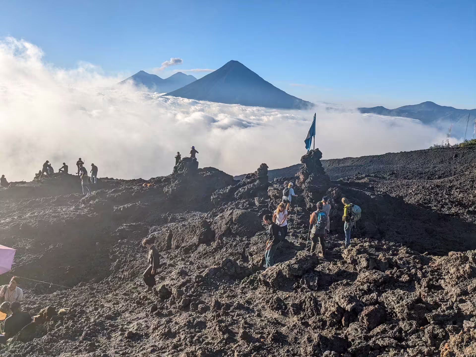 Lávové pole na sopke Pacaya v Guatemale s turistami a výhľadom na okolité vulkány