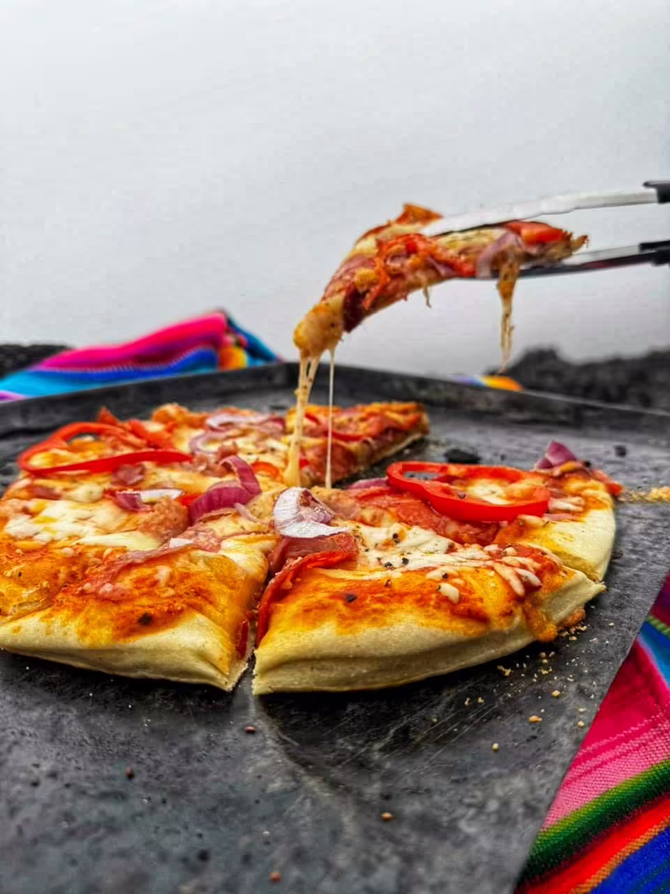 Upečená pizza Pizza Pacaya s paprikou a červenou cibuľou na kovovom podnose
