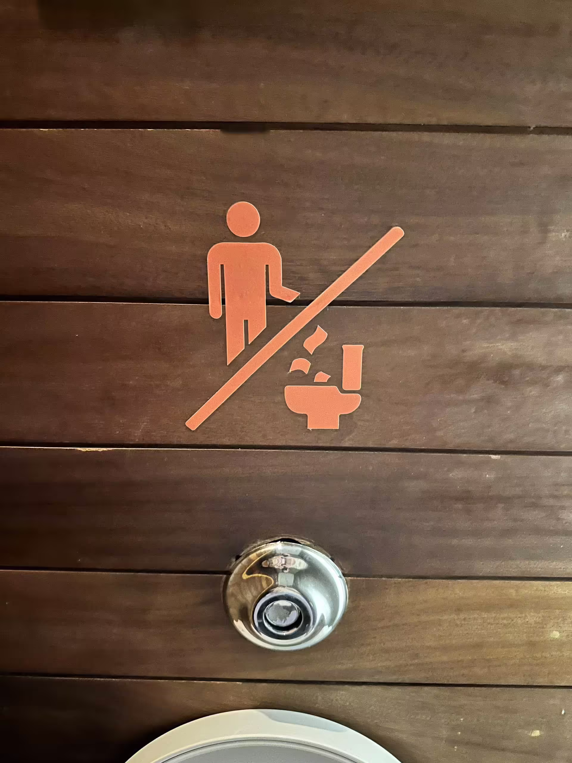 Upozornenie na toalete v Grécku, že papier a odpad nepatria do WC