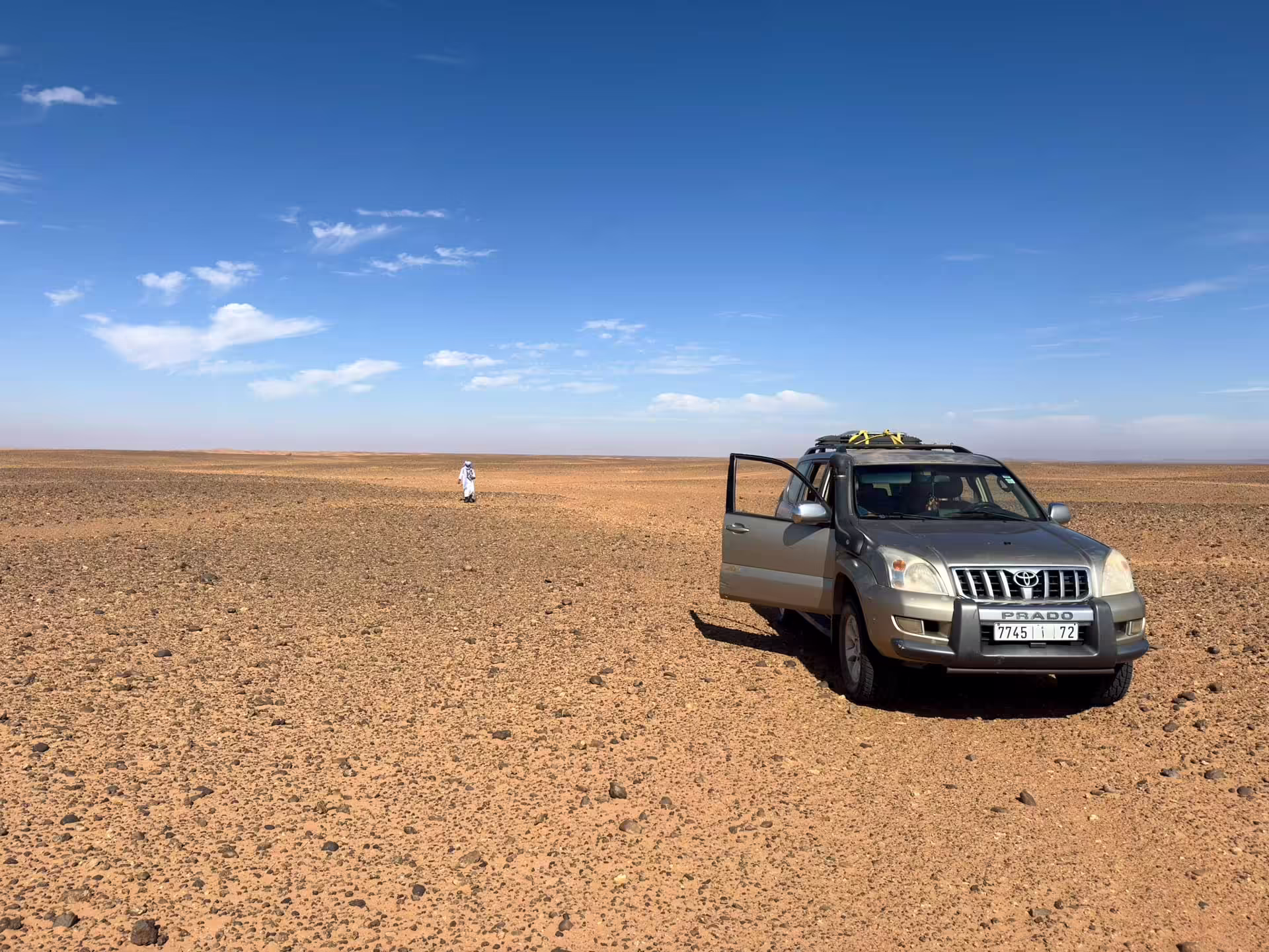 Toyota Prado a človek na rozľahlej kamenistej pláni Sahary, kde sme hľadali fosílie
