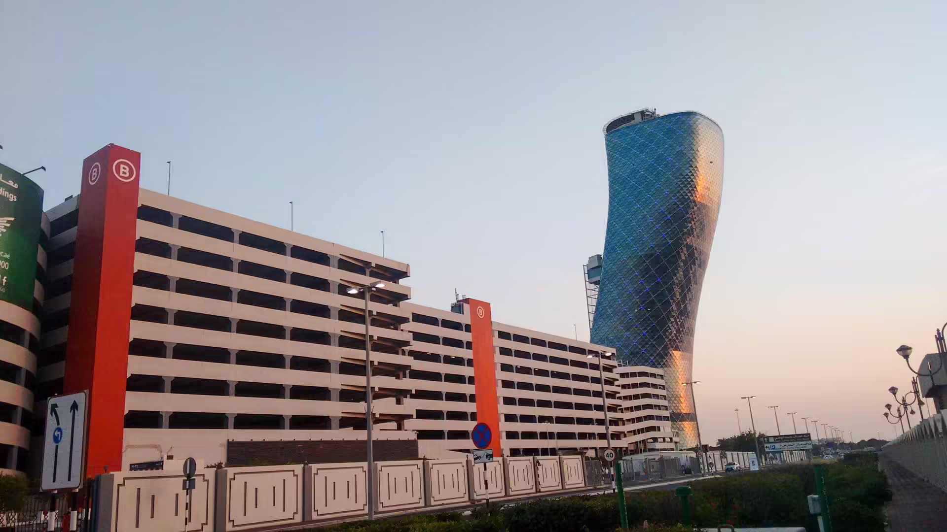 Naklonený mrakodrap Capital Gate v Abú Zabí pri pohľade od parkovacieho domu
