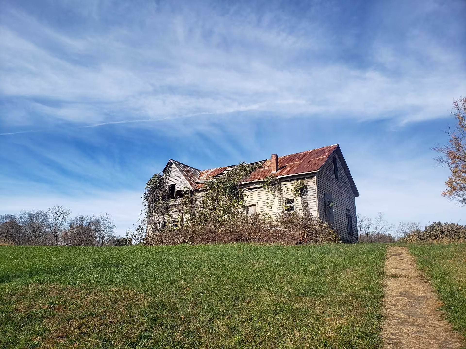 Chátrajúci drevený dom s hrdzavou plechovou strechou v Henry River Mill Village