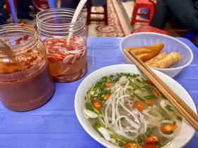 Miska severovietnamského phở v Phở Hàng Trống s čili, nakladaným cesnakom a dầu cháo quẩy