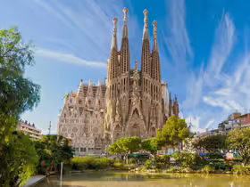 Sagrada Família v Barcelone s vežami nad parkom a jazierkom
