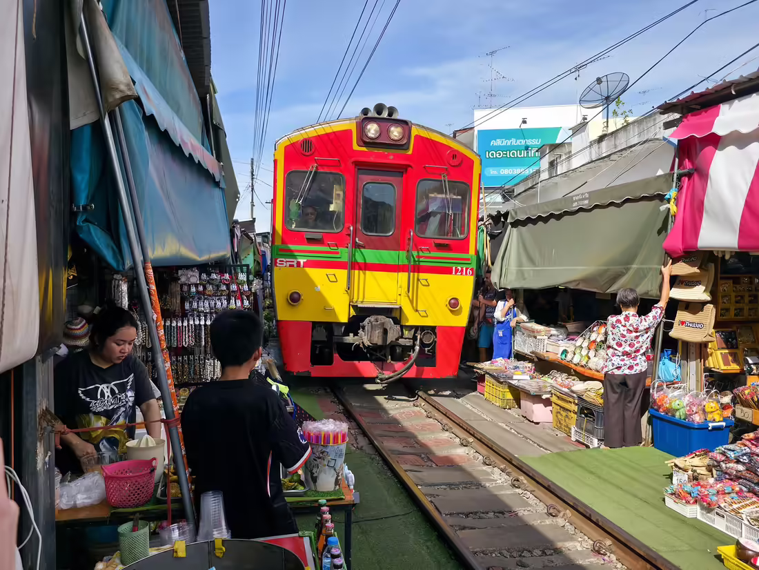 Vlak SRT prechádza medzi stánkami na trhu Maeklong